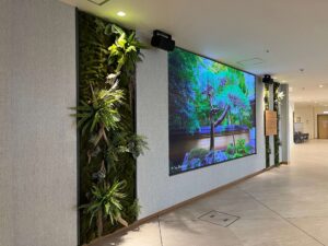 サイネージの両サイドにフェイクグリーンの壁面パネルを設置しました。